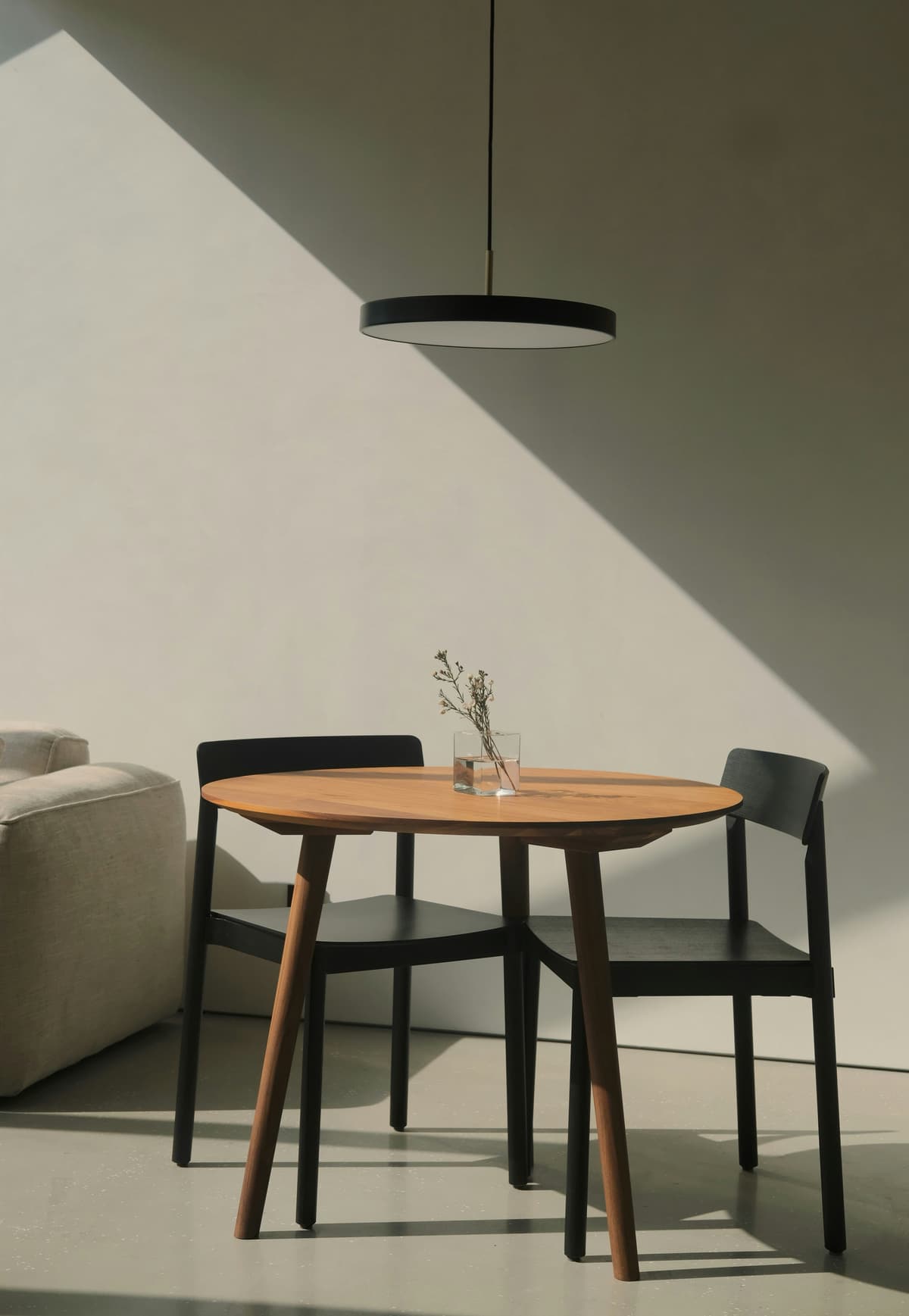 Soft, textured plaster wall finished in a breathable limewash-style paint beside a timber table
